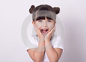 Headshot of impressed attractive little girl opening mouth from amazement and shock holding hands near face