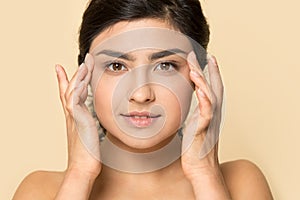 Headshot of indian millennial girl touch healthy skin