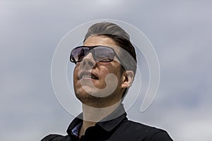 Headshot of Man With Sunglasses Looking Up at the Sky