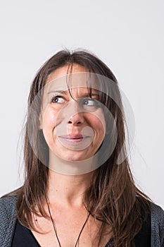 Headshot of a mediterranean woman aged 30-40 with a funny face to the camera looking to her right.