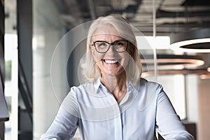 Headshot of middle-aged businesswoman posing at workplace