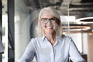 Headshot of middle-aged businesswoman posing at workplace photo