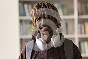 Headshot portrait African guy with dreadlock hairstyle pose in library