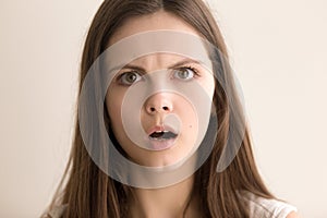 Headshot portrait of astonished young woman