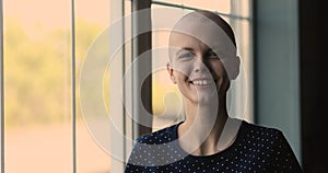 Headshot portrait bald female cancer patient smiling looking at camera
