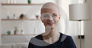 Headshot portrait bald woman sitting indoor smiling look at camera