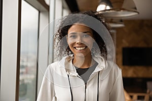 Headshot portrait of beautiful smiling millennial afro american female indoors