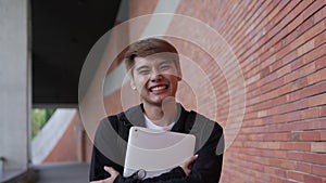 Headshot portrait of a cheerful young happy Asian college student with a smile and looking at the camera. Laughing enjoying