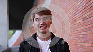 Headshot portrait of a cheerful young happy Asian college student with a smile and looking at the camera. Laughing enjoying