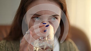 Headshot portrait of depressed stressed adolescent girl drinking water looking away. Close-up Caucasian teenager indoors