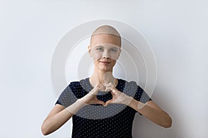 Headshot portrait of hairless sick woman show heart gesture