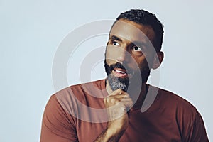 headshot portrait of a handsome bearded mid adult man smiling looking away at copy space against gray background