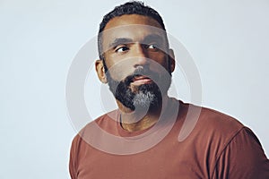 headshot portrait of a handsome bearded mid adult thoughtful man looking away at copy space against gray background