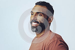 headshot portrait of a handsome bearded mid man smiling looking away at copy space against gray background