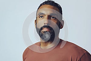 headshot portrait of a handsome thoughtful bearded mid man looking away at copy space against gray background