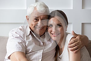 Headshot portrait of happy adult dad and daughter hugging