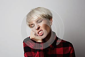 Headshot Portrait of happy blonde girl posing in a red shirt in a big cage.White background.