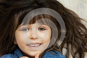 Headshot portrait of happy child. Awesome girl with curly brown-haired,