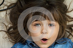 Headshot portrait of happy child. Awesome girl with curly brown-haired,