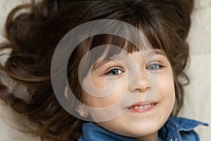 Headshot portrait of happy child. Awesome girl with curly brown-haired,