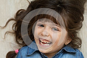 Headshot portrait of happy child. Awesome girl with curly brown-haired,