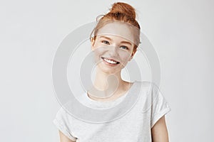 Headshot Portrait of happy ginger girl with freckles smiling looking at camera. White background.