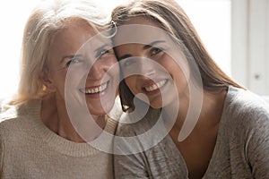 Headshot portrait of happy mature mom and adult daughter