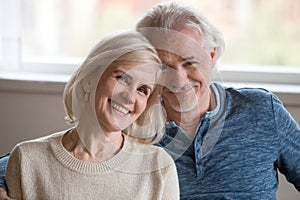 Headshot portrait of happy middle aged romantic couple posing in