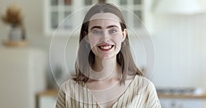 Headshot portrait of happy young woman pose in kitchen