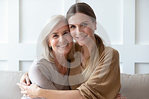 Headshot portrait of mature mom and adult daughter posing photo