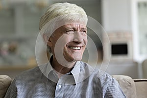 Headshot portrait optimistic healthy retired older man smile looks aside