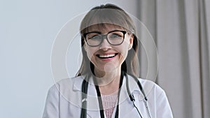 Headshot portrait of positive smiling female doctor in office