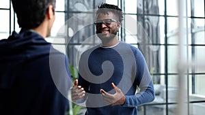 Headshot portrait of a smiling businessman offering a handshake. Business concept