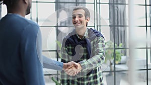 Headshot portrait of a smiling businessman offering a handshake. Business concept