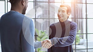 Headshot portrait of a smiling businessman offering a handshake. Business concept