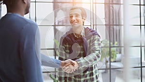 Headshot portrait of a smiling businessman offering a handshake. Business concept