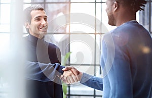 Headshot portrait of a smiling businessman offering a handshake. Business concept