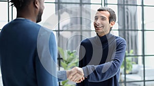 Headshot portrait of a smiling businessman offering a handshake. Business concept