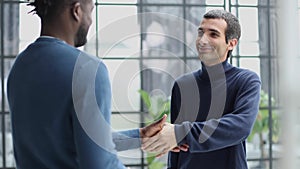 Headshot portrait of a smiling businessman offering a handshake. Business concept