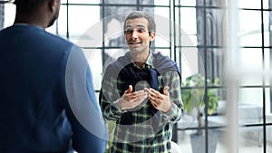 Headshot portrait of a smiling businessman offering a handshake. Business concept