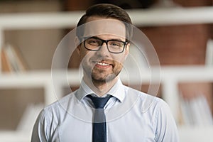 Headshot portrait of smiling Caucasian businessman in glasses