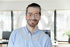 Headshot portrait of smiling Caucasian businessman pose in office