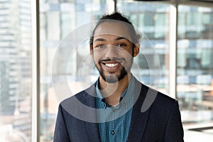 Headshot portrait of smiling ethnic businessman in office photo