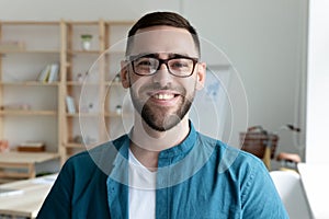 Headshot portrait of smiling male employee in office