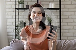 Headshot portrait of smiling millennial girl using cellphone