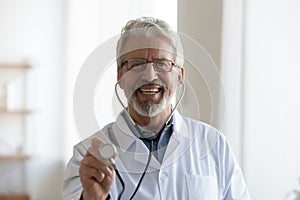 Headshot portrait of smiling mature male doctor with stethoscope