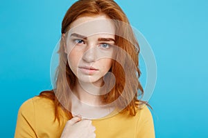 Headshot Portrait of tender redhead teenage girl with serious expression looking at camera. Caucasian woman model with