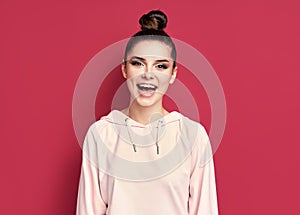 Headshot portrait of young happy woman smiling and looks at camera