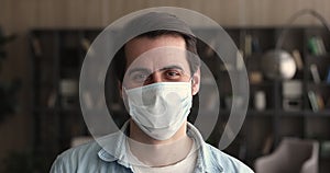 Headshot portrait young man in surgical protective face mask