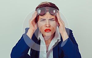 Headshot serious angry bitchy woman wife holding sunglasses up skeptically looking at you isolated green wall background blue suit